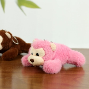 Detail of pink and brown plush monkey keychains with soft faux fur and metal rings