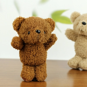 Macro detail of dark brown curly plush teddy bear charm with soft fluffy texture