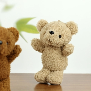 Detailed view of the soft curly plush texture on a light brown teddy bear charm