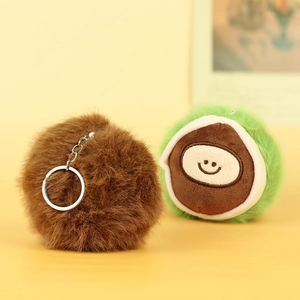 Macro detail of plush chestnut and kiwi charms with cute embroidered faces and silver rings