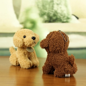Close-up of beige and brown teddy dog plush keychains on a rustic wooden table