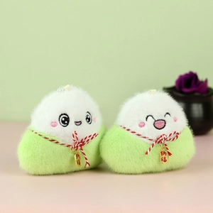 Gros plan d'un mignon porte-clés en peluche avec feuilles vertes et breloque dorée