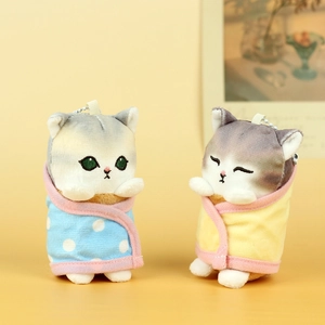 Cute plush shark cat charms in blue and yellow wraps with metal chains on yellow backdrop