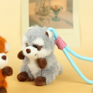 Macro detail of plush animal keychain with blue braided rope and fluffy fur texture