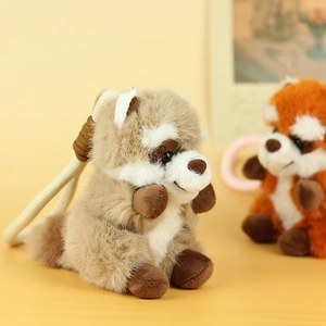 Detail of plush raccoon keychain featuring soft faux fur texture and a woven hanging strap