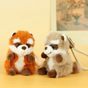 Detailed view of plush red panda and raccoon bag charms with woven lanyards