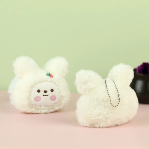 Dettaglio portachiavi a forma di coniglio in peluche bianco con ricamo e fragolina