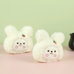 Dettaglio di ciondoli a coniglietto in peluche bianco con fragole ricamate sulle orecchie
