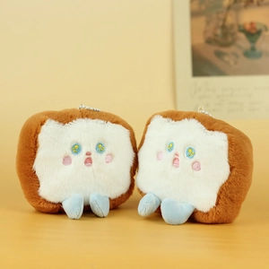Close-up of two cute bread plush charms with embroidery details and metal bead chains
