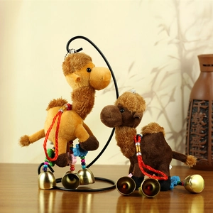 Detail of plush camel keychains with colorful ethnic beads and gold bells on display