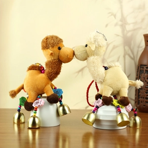 Detailed close-up of cute camel plush keychains with golden bells and wooden fish charms