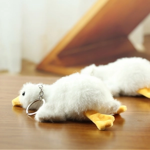 Close-up of white plush goose keychain with soft fur and silver metal ring