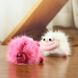 Gros plan de pendentifs en peluche rose et blanc avec de grosses lèvres sur bois