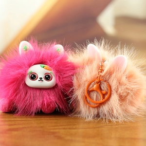 Détail macro de pendentifs monstre en peluche avec grands yeux et fourrure douce