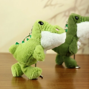 Nahaufnahme grüner Plüsch-Dinosaurier-Anhänger mit weichem Fell und Metallclip