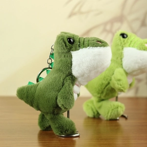 Detailansicht eines grünen Plüsch-Dinosaurier-Anhängers mit weicher Textur und Ring