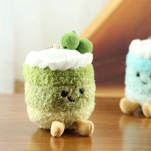 Detalle del adorable colgante de pastel de cereza de peluche con cara sonriente bordada