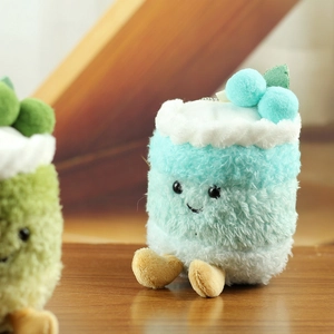 Detalle de un tierno colgante de pastel de peluche azul con bordado de cara sonriente