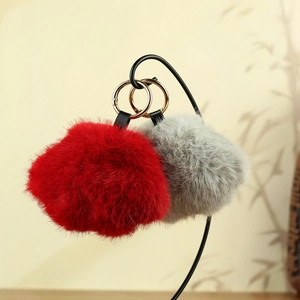 Porte-clés patte de chat en peluche rouge et gris suspendus sur un support en métal chic
