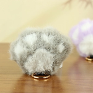 Détail d'un porte-clés en peluche douce grise et blanche avec anneau en métal doré