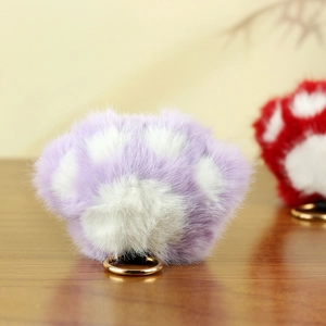 Détail d'un porte-clés patte de chat en peluche violette avec anneau doré métallique