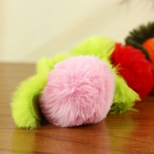 Dettaglio di morbidi ciondoli a forma di frutta in finta pelliccia rosa e verde