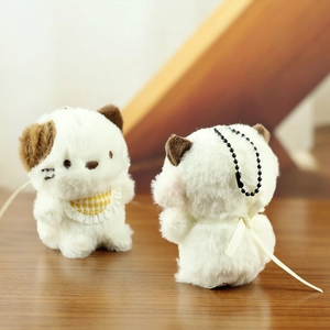 Macro detail of plush puppy keychain charms showing soft texture and ribbon bow