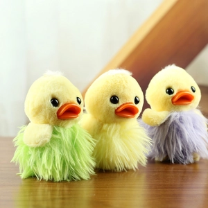 Three yellow plush duck keychains with colorful lace skirts on a wooden surface