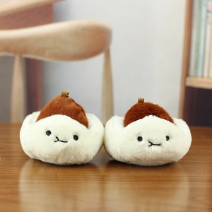 Plush steamed bun keychain charm set with cute embroidery on a warm wooden background