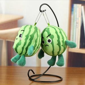Close-up of cute plush watermelon keychain with smiling and angry embroidery details