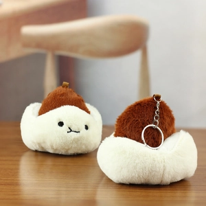 Detail of cute plush bun keychain with soft texture and silver metal ring on wood surface