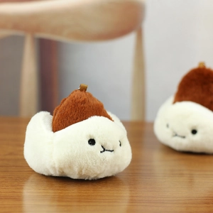 Detailed close-up of cute steamed bun plush charm with embroidered face and soft texture