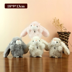 Cute bunny plush keychains in four colors with heart pendants on a wooden surface