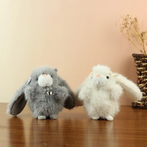Detail of plush bunny pendants featuring soft long fur and delicate lace bow accents