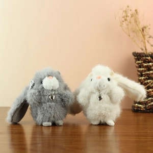 Detailed view of grey and white plush bunny pendants with pearl and heart necklace