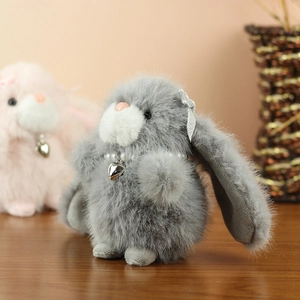 Close-up of plush rabbit keychain with pearl collar and heart pendant detail