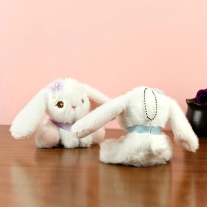Vista dettagliata del portachiavi a forma di coniglio di peluche bianco con fiori