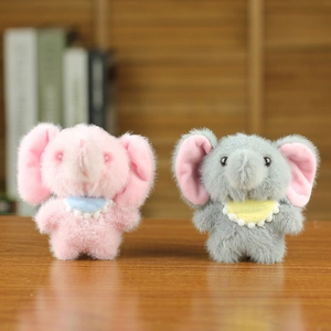 Cute plush elephant keychain pendants in pink and grey with decorative bibs on wooden desk