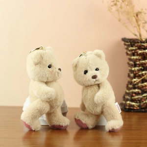 Detail of soft beige plush teddy bears with golden keychains and TOOT woven labels