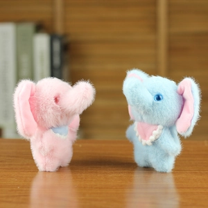 Close-up of pink and blue plush elephant keychain dolls on a warm wooden desk