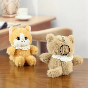 Detail of cute orange and white plush cat keychain with lace collar and metal clip