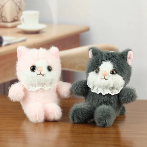 Plush cat toys in pink and grey with lace scarves on a cozy wooden surface