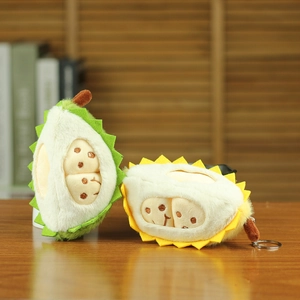 Détail de mignons porte-clés durian en peluche vert et jaune avec visages brodés