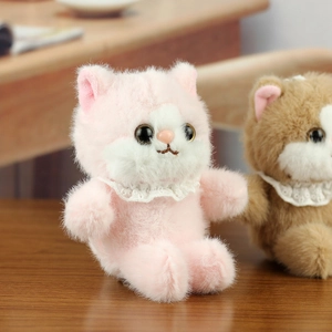 Close-up of soft cat plush toys in pink and brown with lace collars on wood