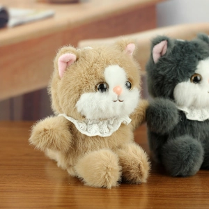 Close-up of fluffy plush cat dolls with lace collars on a natural wooden surface