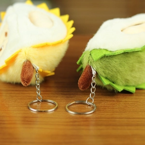 Gros plan de porte-clés durian en peluche jaune et vert sur une table en bois