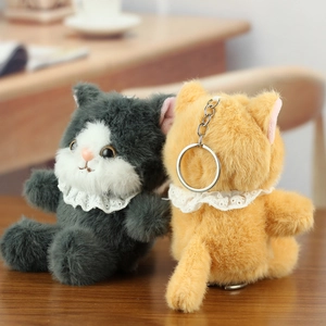 Detail of plush cat keychains with lace collars in grey and ginger on wooden surface