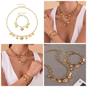 Detailed shot of gold beaded necklace and bracelet set with sparkling puppy charms