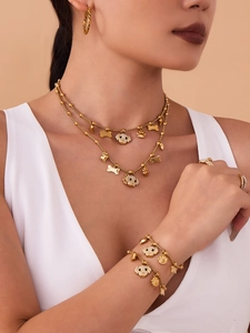 Detailed view of gold dog-themed jewelry set with sparkling crystals on a model
