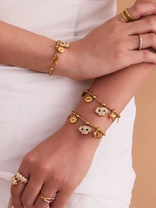 Detailed view of gold puppy charms with sparkling cubic zirconia on bracelets and rings